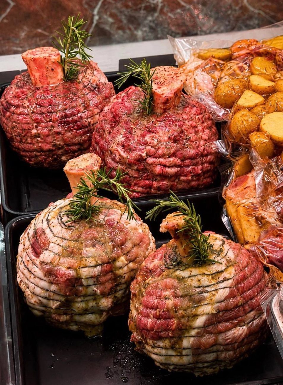 Rolled roasts tied with rosemary, ready for the oven