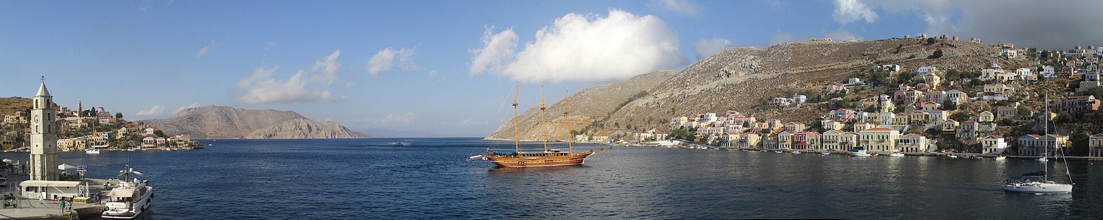 Panorama of Symi harbour with colourful houses on both sides of the inlet