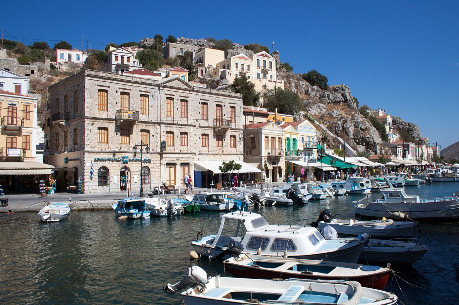Boats and neoclassical buildings along the quay at Symi