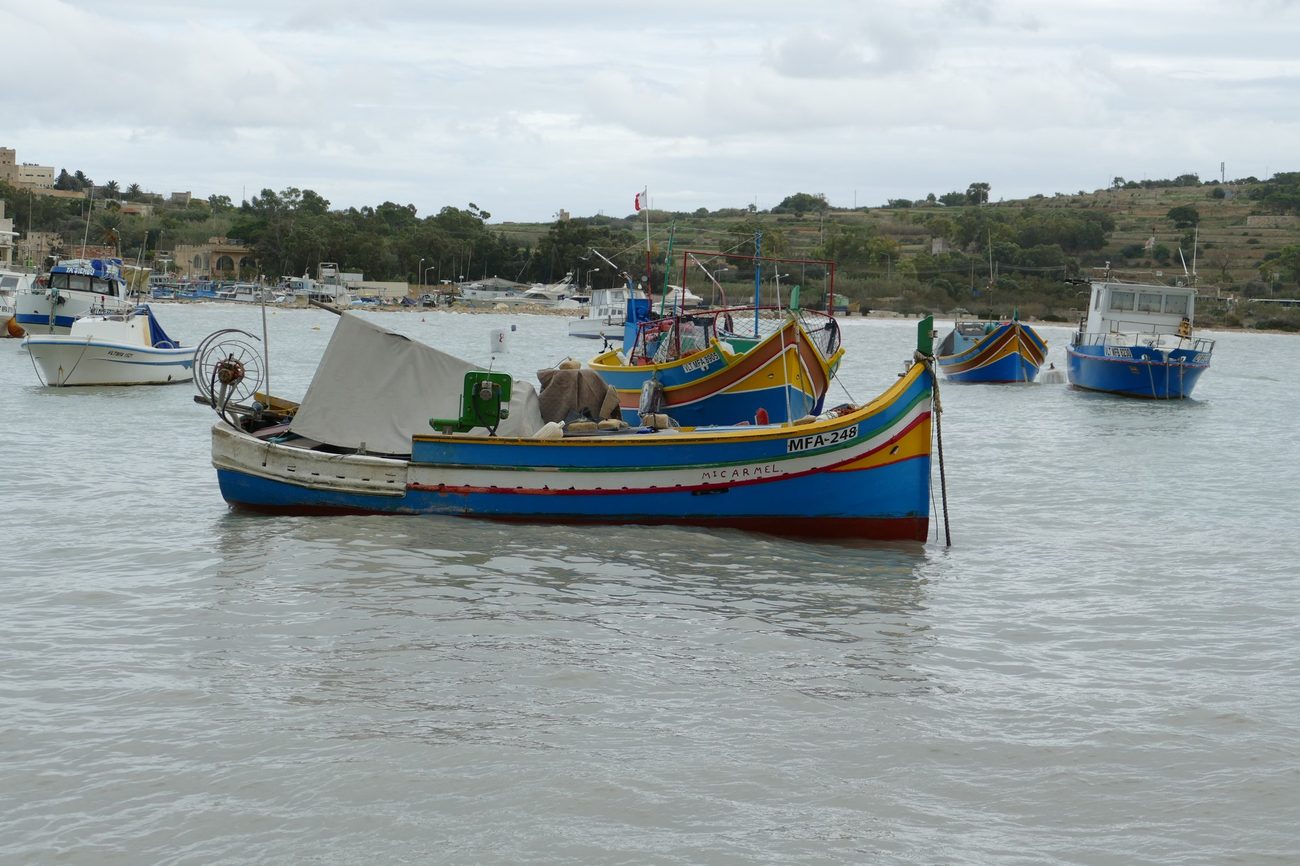 A single painted luzzu moored at Marsaxlokk