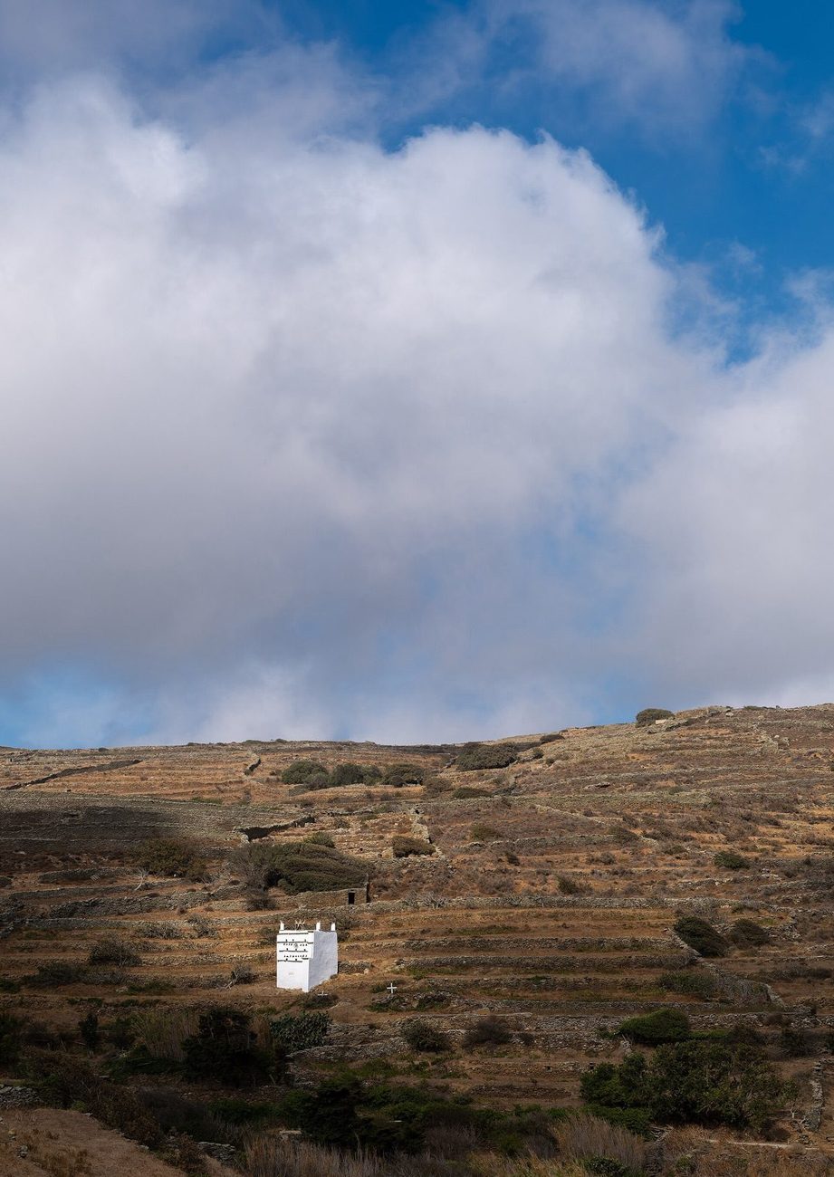 An ornate stone dovecote amid terraced fields at Tarambados, Tinos