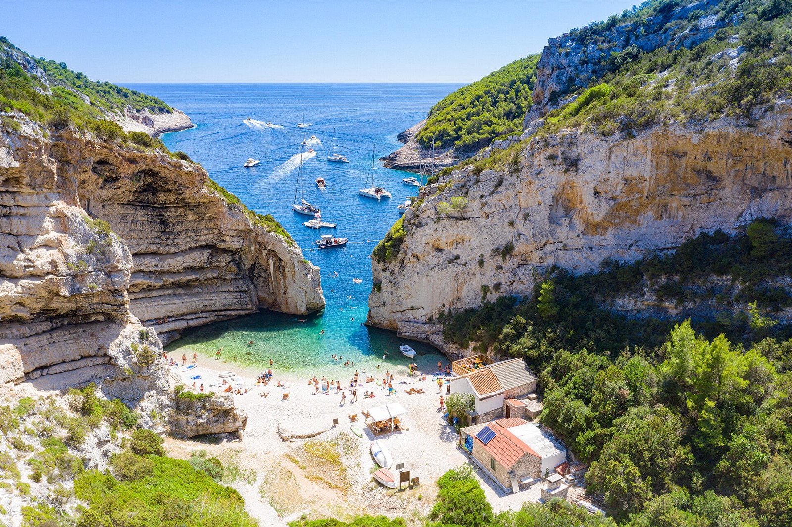 Aerial view of Stiniva cove on Vis, Croatia, entered through a narrow gap in the cliffs
