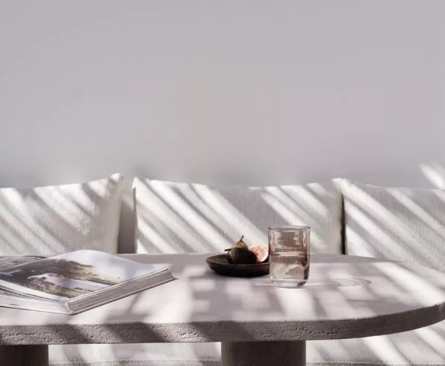 A pale-timber interior at Kalesma Mykonos, light raking across linen