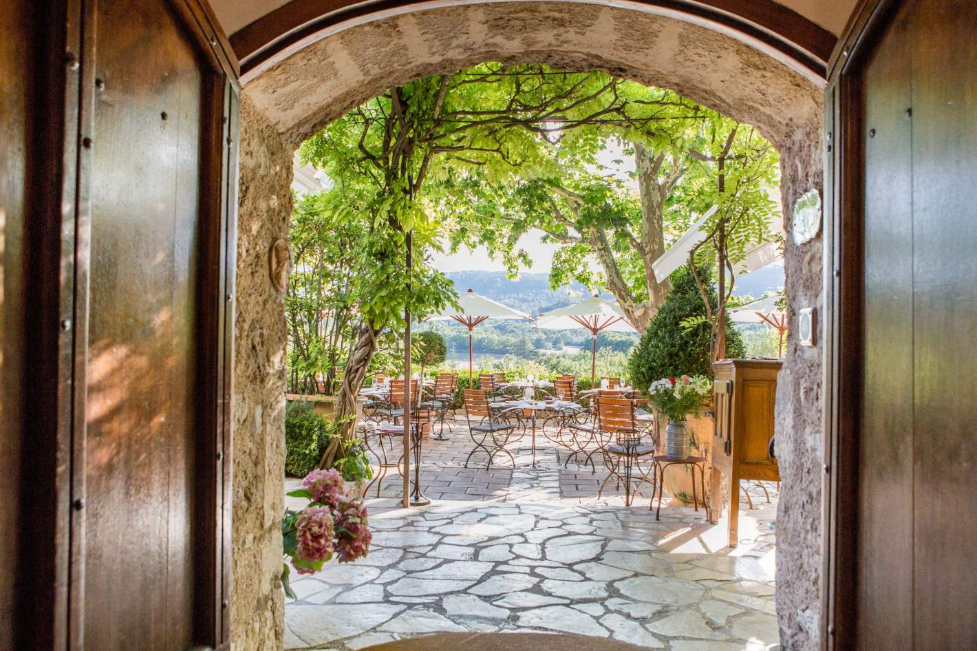 The restaurant terrace laid for lunch under the plane trees