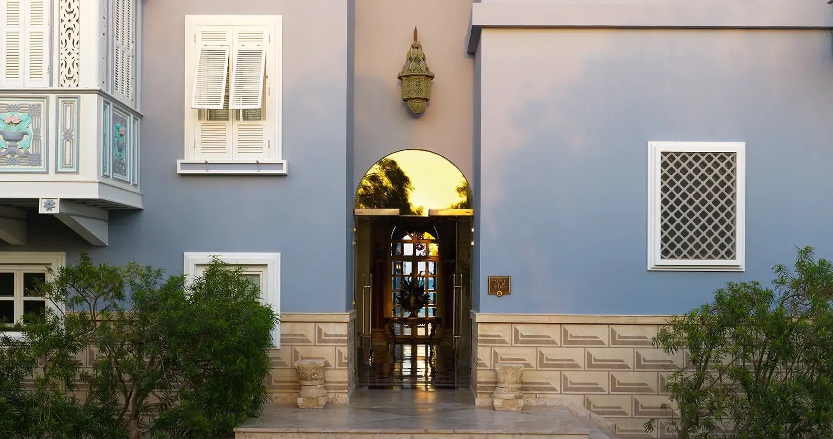 The blue entrance front, with a Moorish lantern and latticed shutters