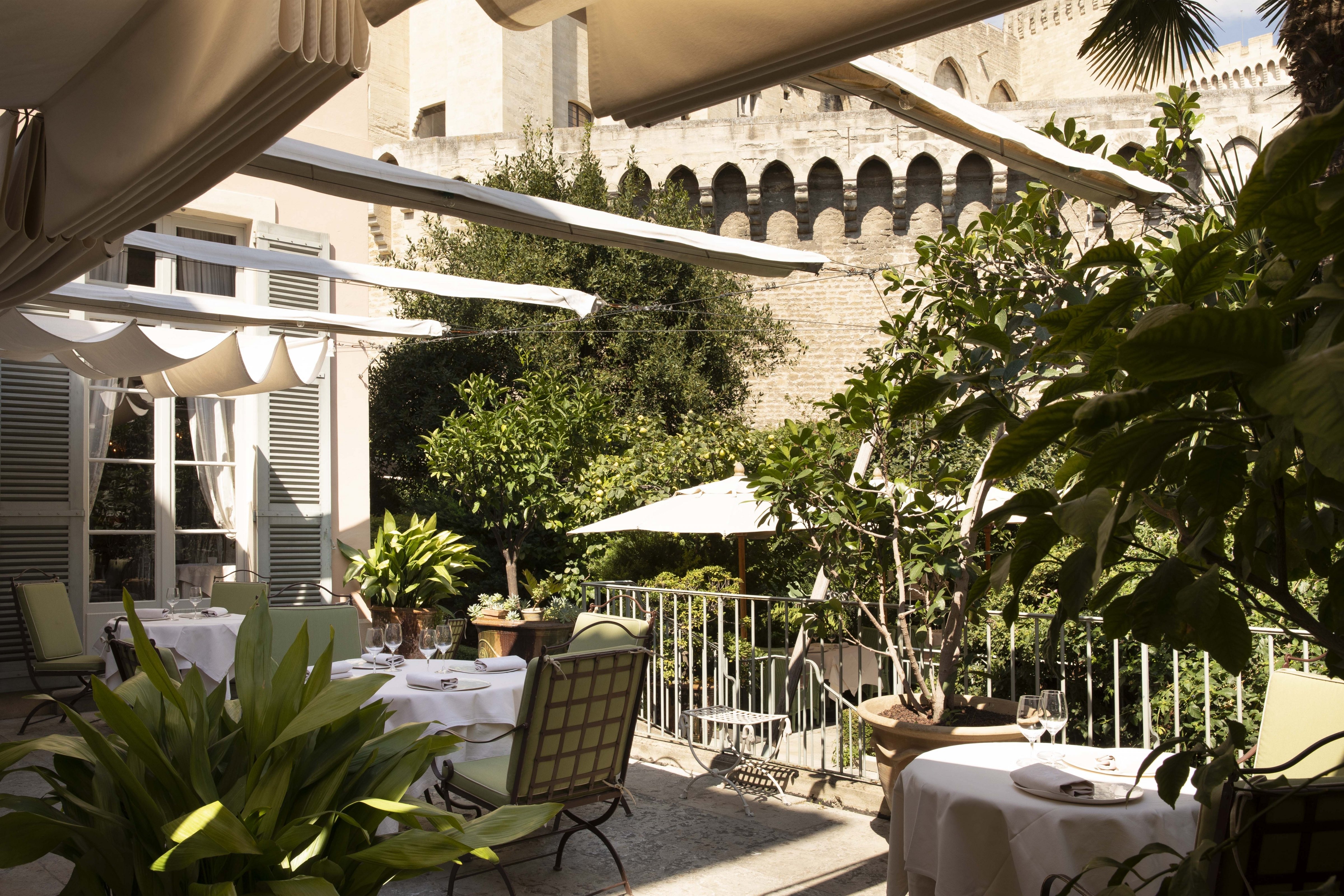Tables set on the garden terrace beneath the ramparts of the Palais des Papes