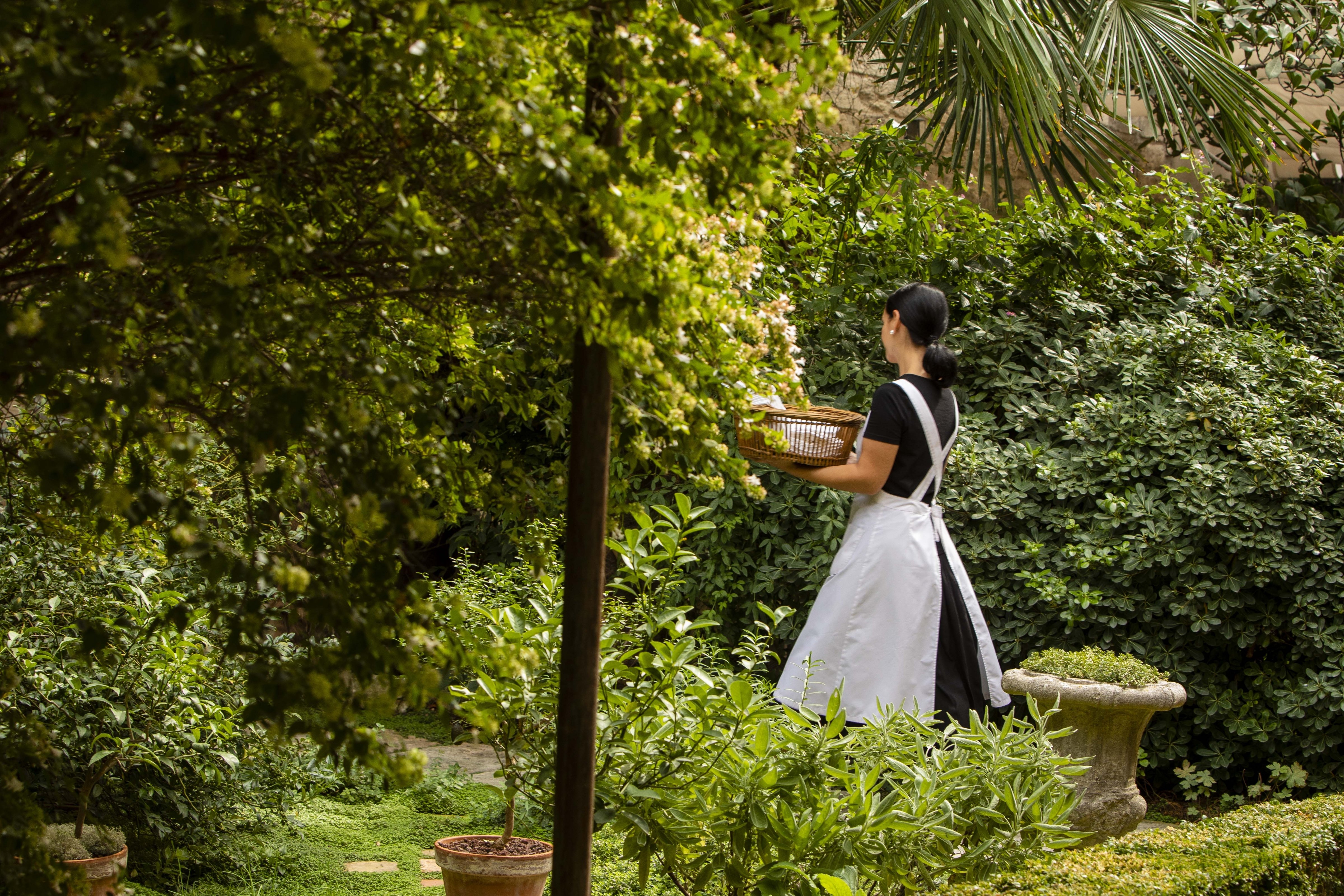 A maid crossing the walled garden behind the house