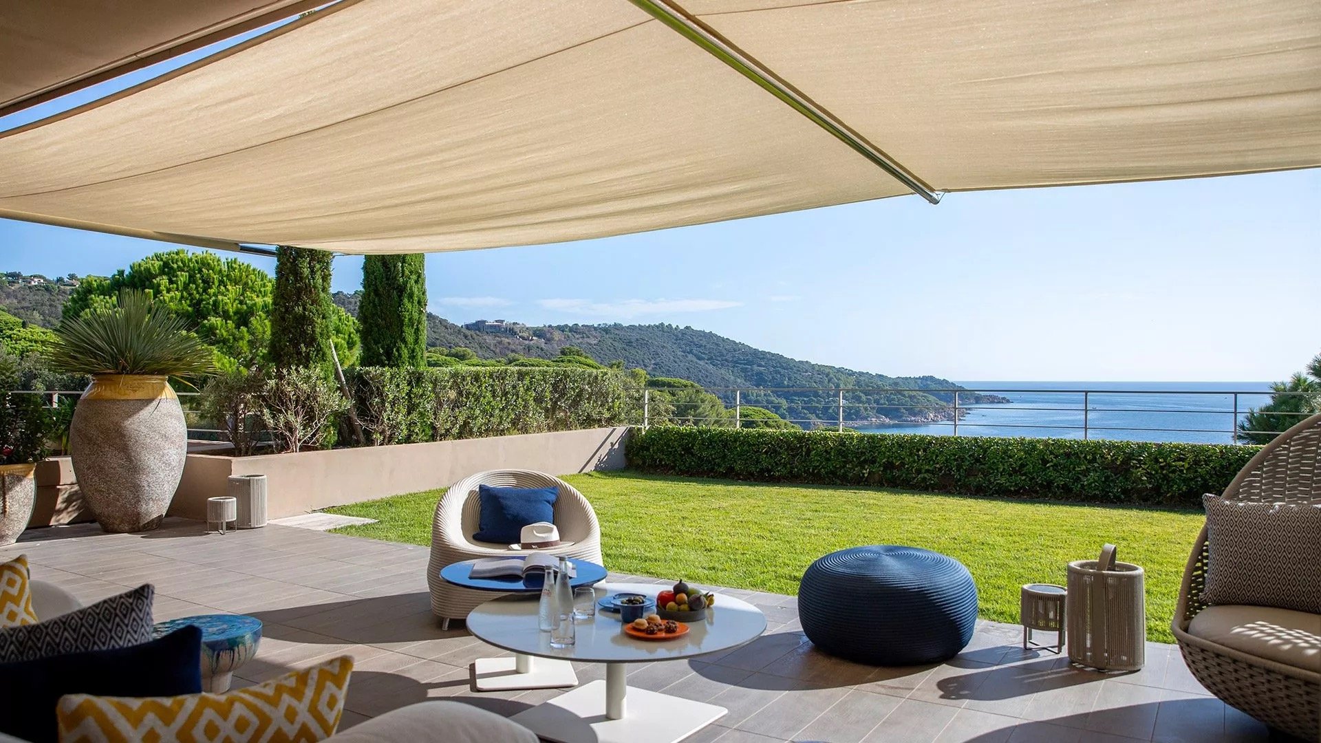 A suite terrace opening onto gardens and the coastline below