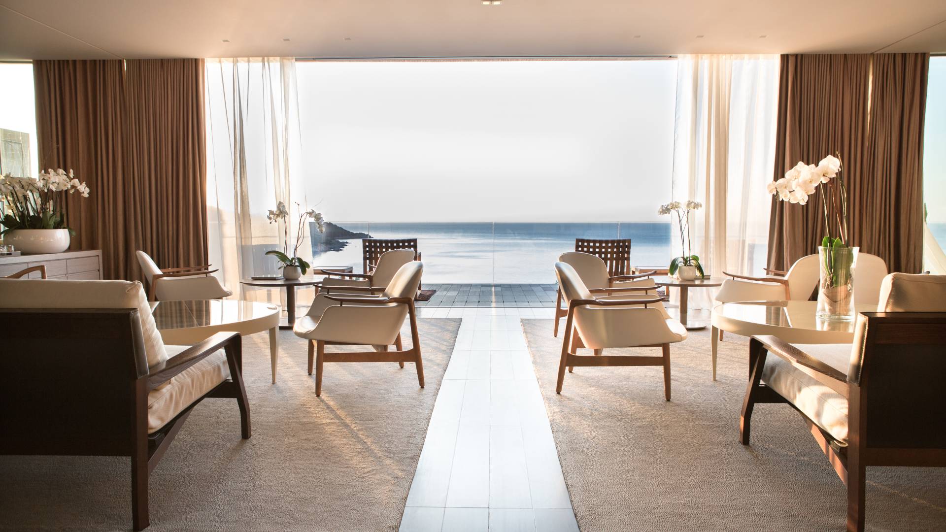 A light-filled salon framing the sea through full-height windows