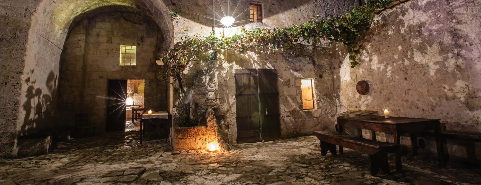 The candlelit courtyard of the cave complex at night