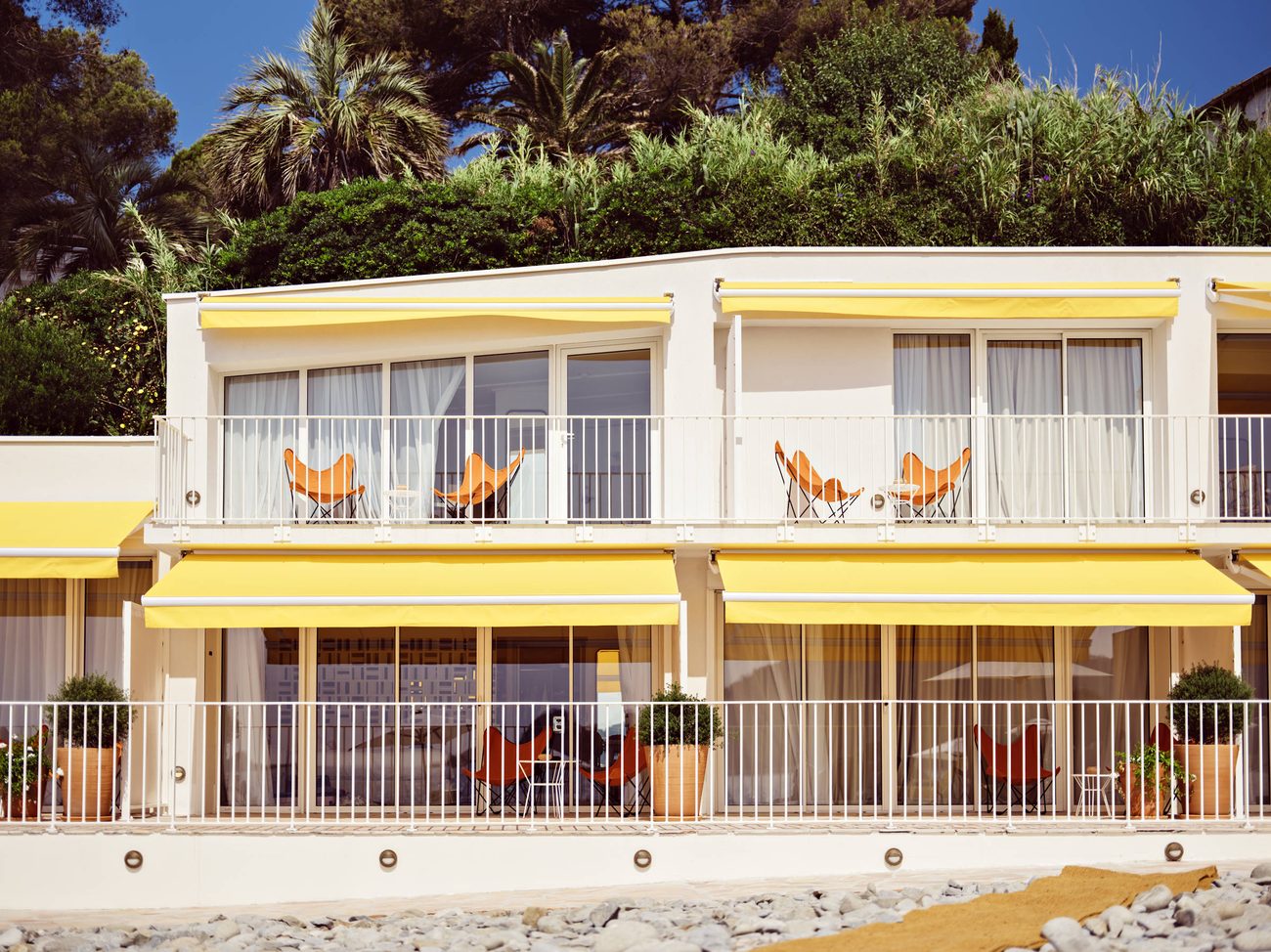 The modernist balconies of Les Roches Rouges with yellow awnings and orange butterfly chairs