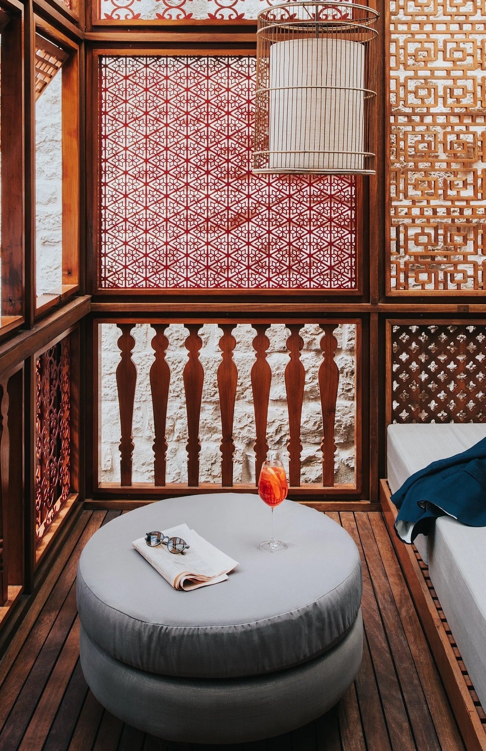 A suite terrace with carved wooden Silk Road screens and a daybed
