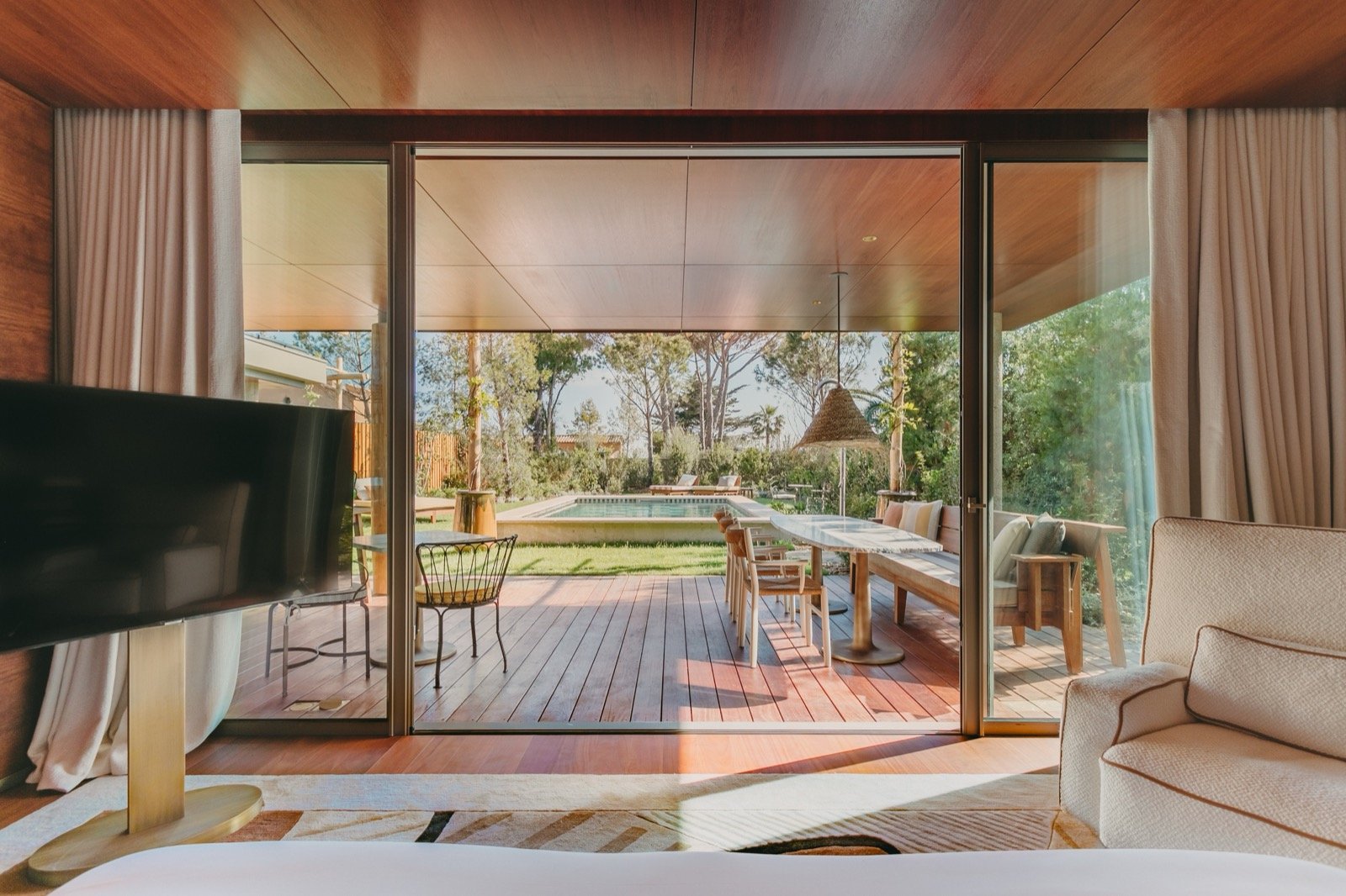 A room opening through glass to a private terrace and garden