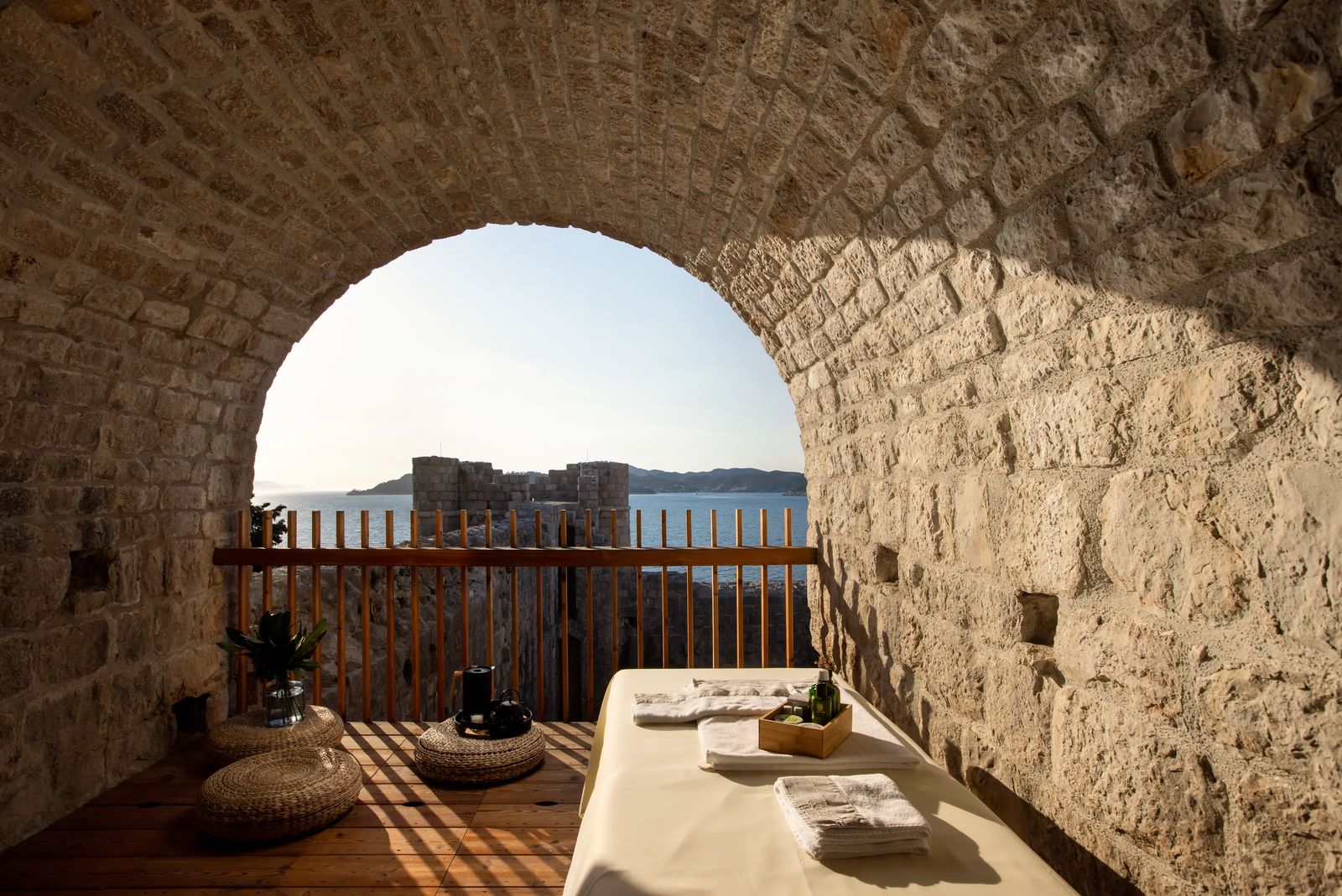 An arched opening in the fortified walls framing the Adriatic