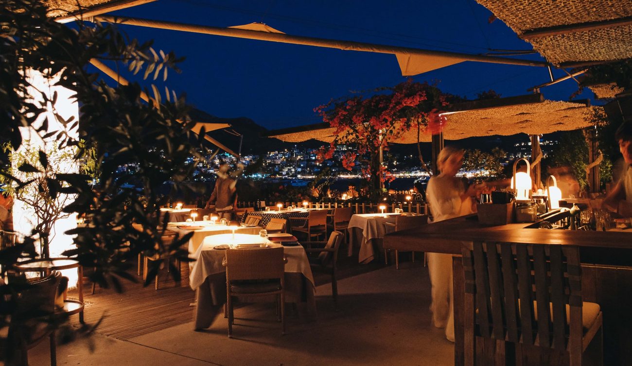 Dinner by candlelight with the lights of the bay beyond