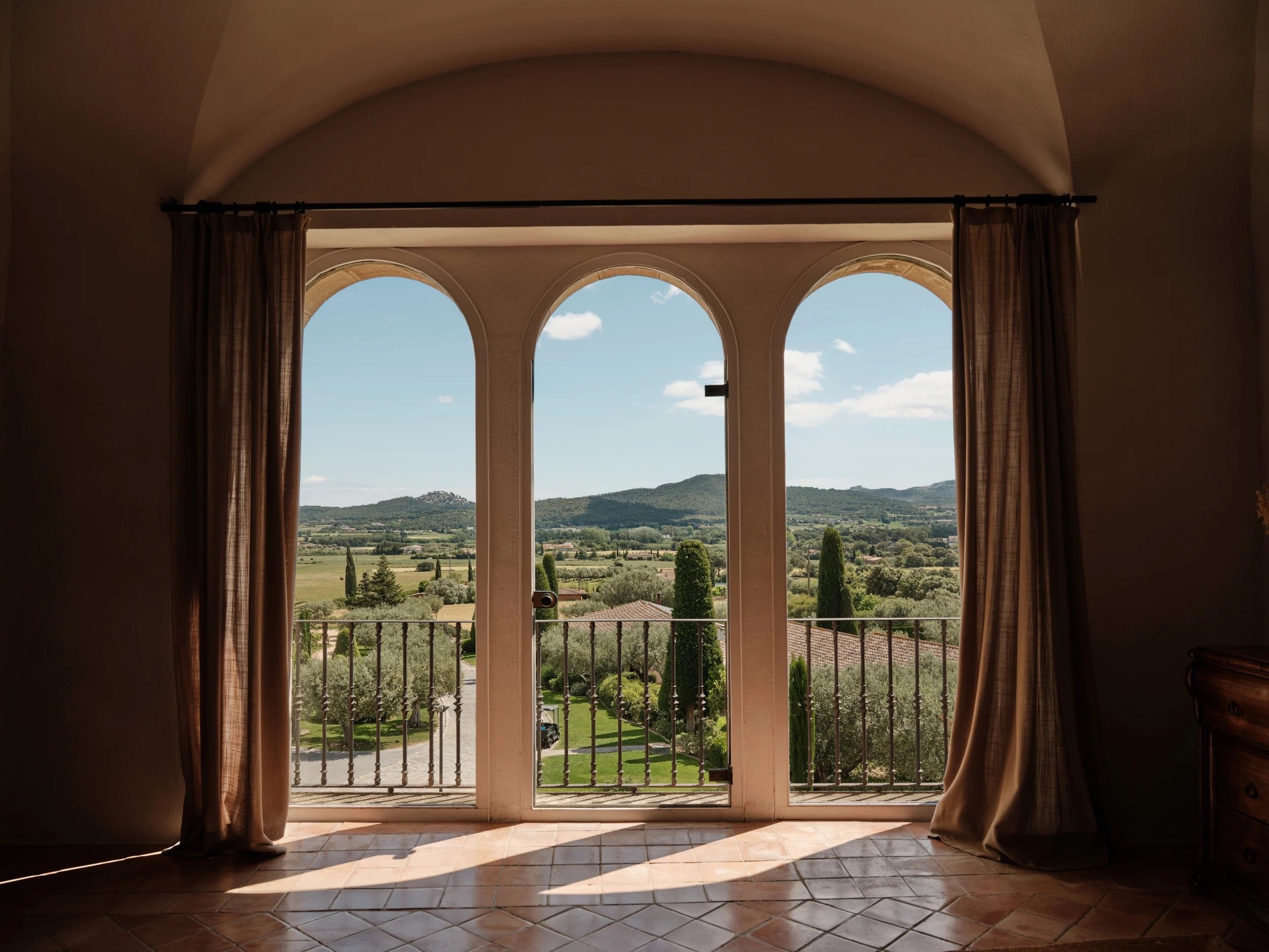 The Empordà countryside seen through an arched stone window