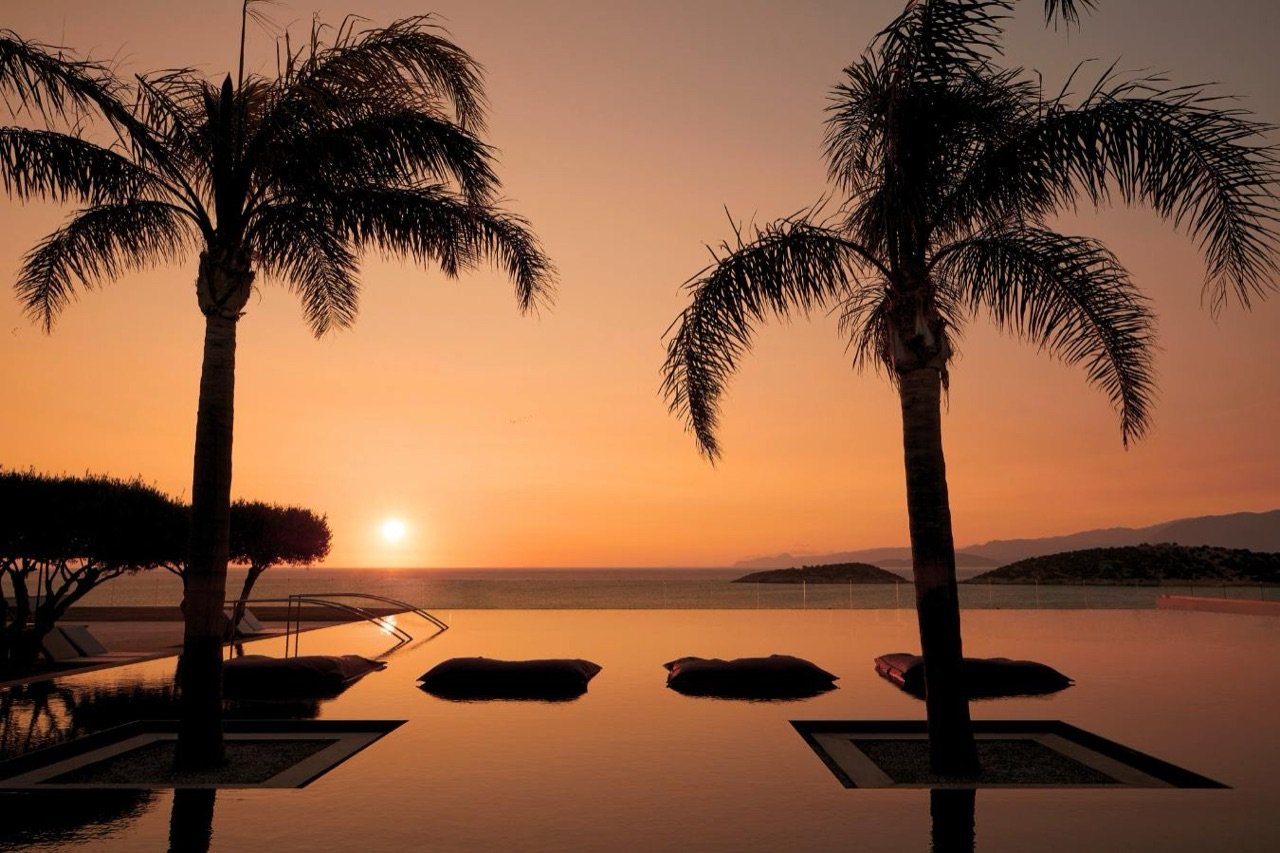 Infinity pool at sunrise over Mirabello Bay