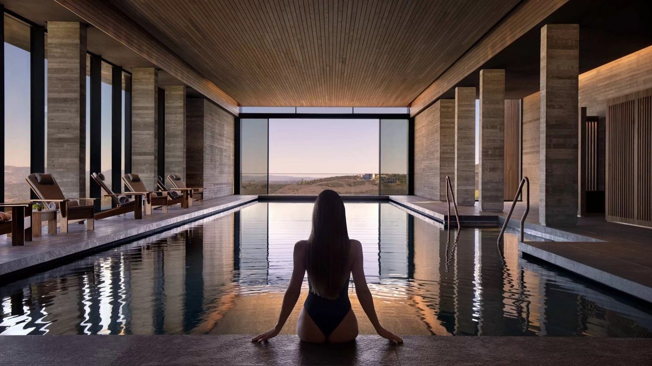 The Minthis Spa indoor pool with a wall of glass onto the hills
