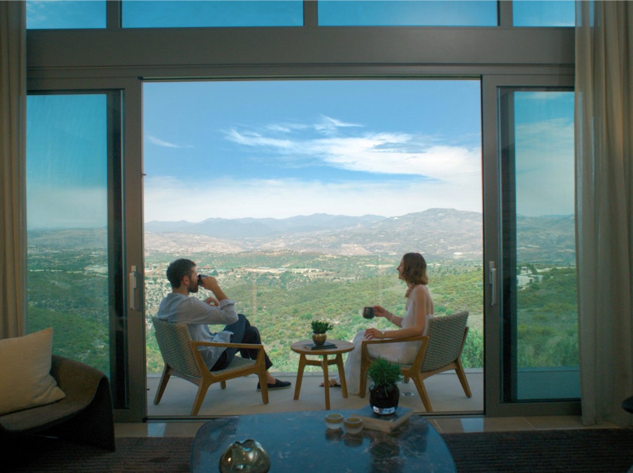 A suite living room opening to a balcony above the valley