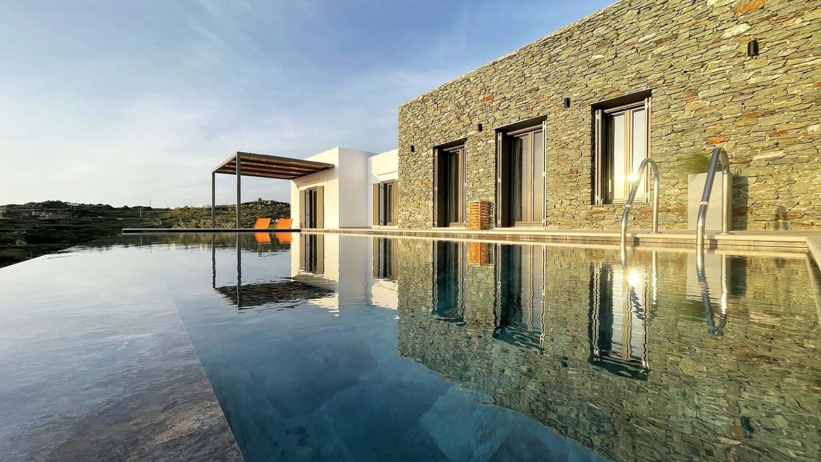 An open living room in stone, wood and linen opening to the terrace