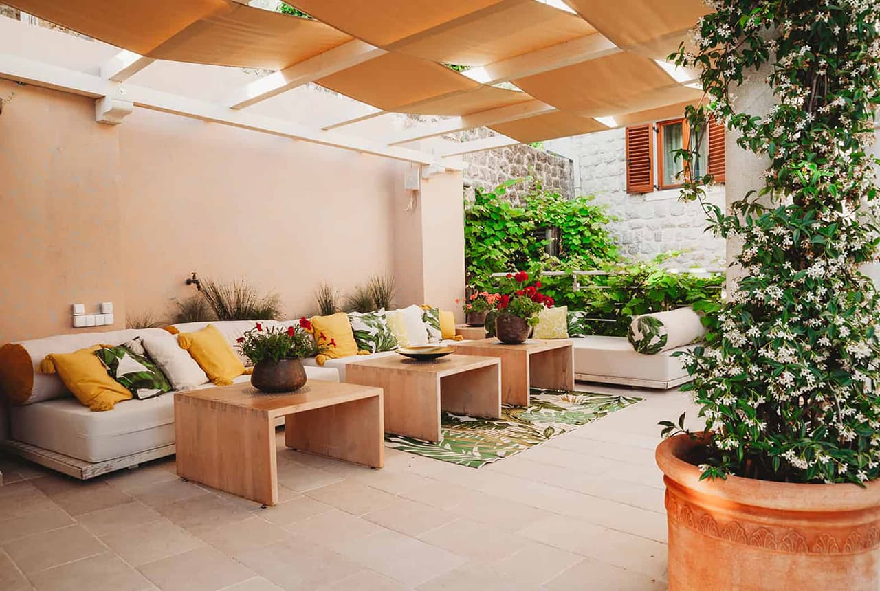 A shaded courtyard lounge with cushioned seating
