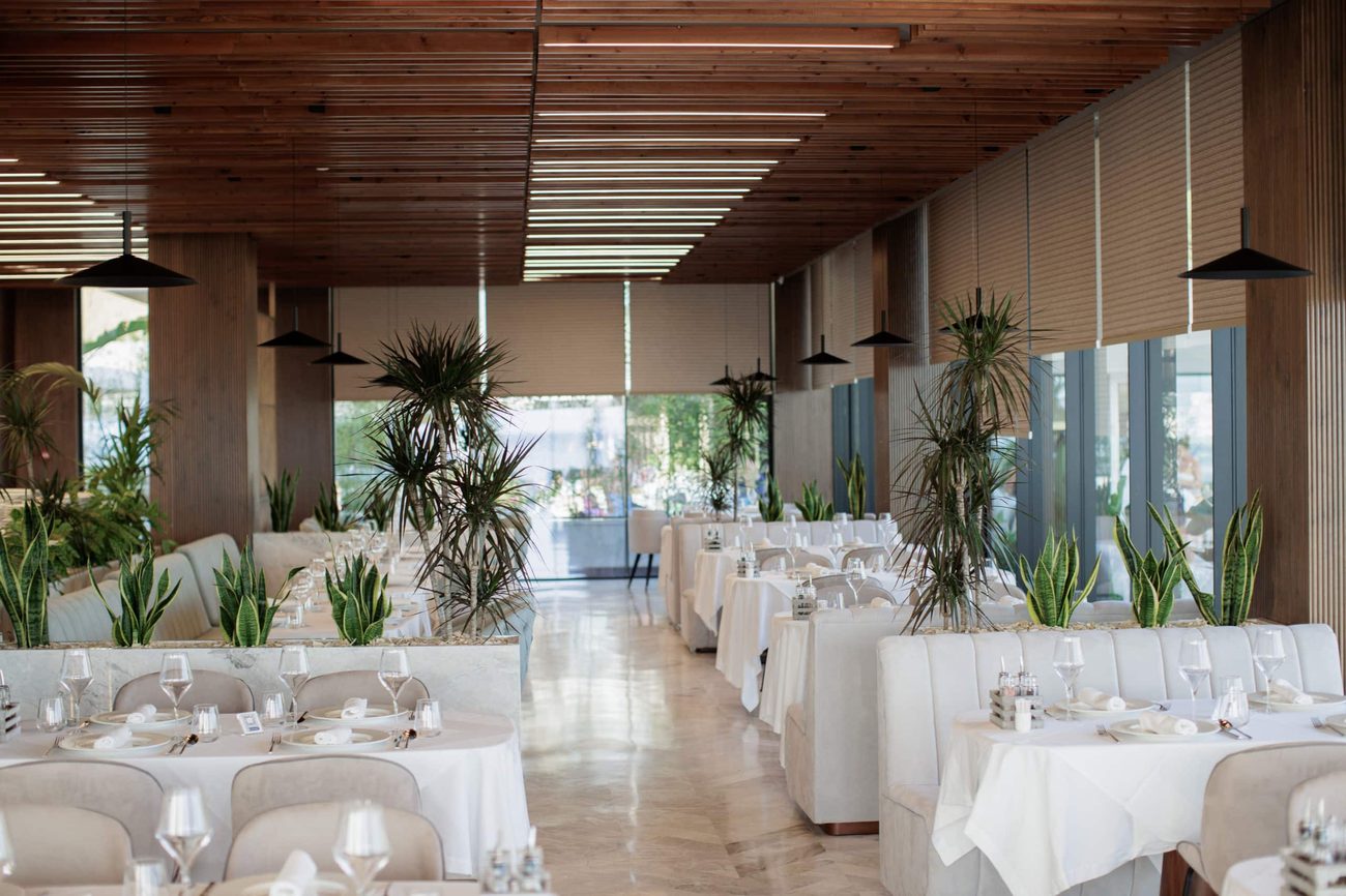 The sea-facing restaurant, tables set under a timber-slatted ceiling