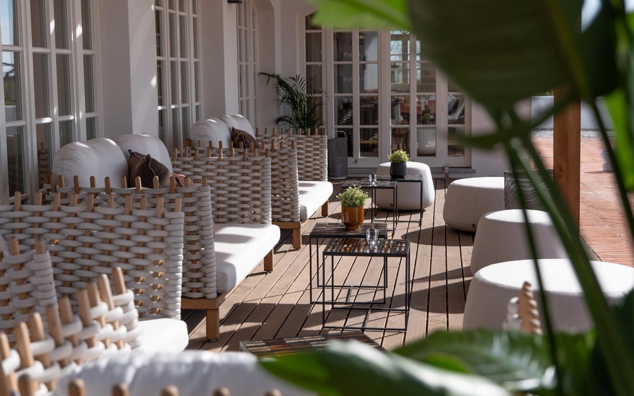 The estate lounge with woven chairs opening onto a shaded veranda