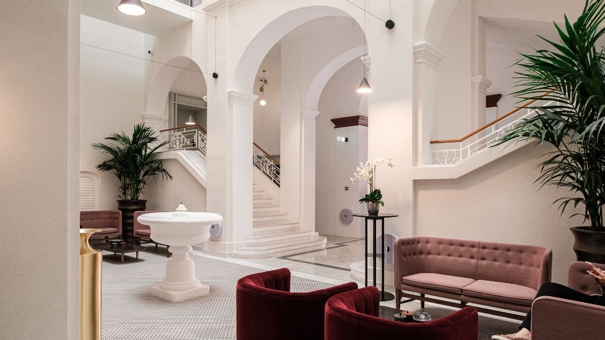 The palazzo's arched entrance hall, with a stone fountain and a sweeping staircase