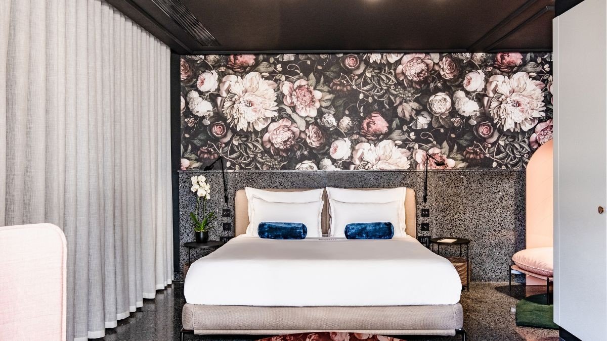 A suite with a dark floral headboard and blue accents