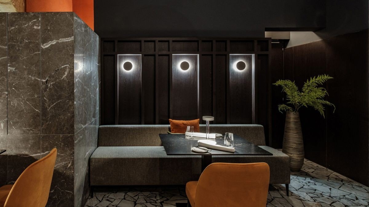 A low-lit lounge with orbs of light and velvet seating