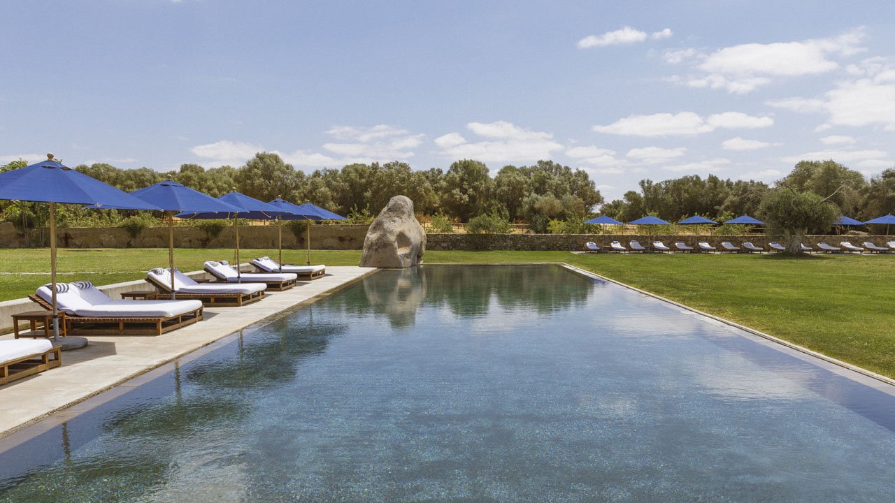 The outdoor pool below the whitewashed buildings of the estate