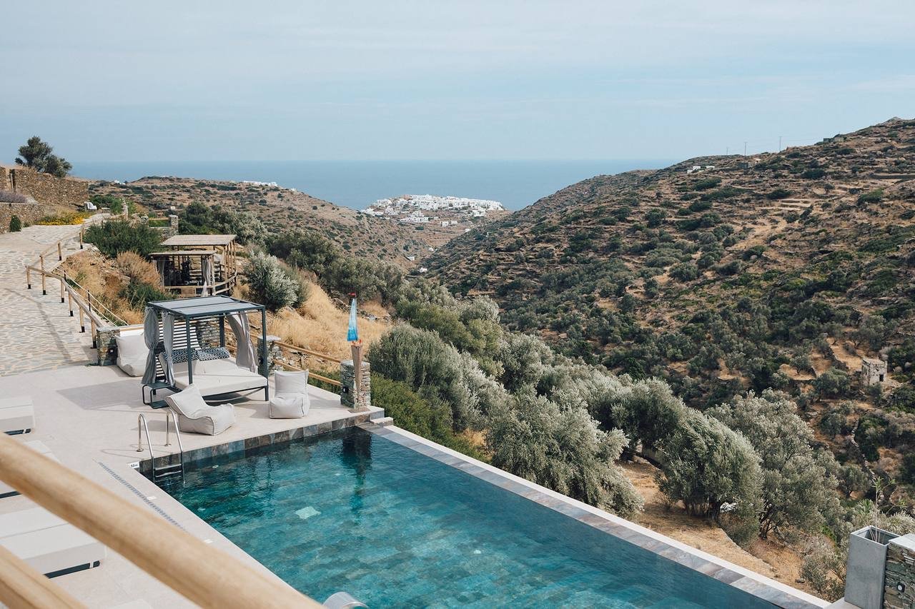 Infinity pool framed by olive trees, looking to the Kastro and the sea