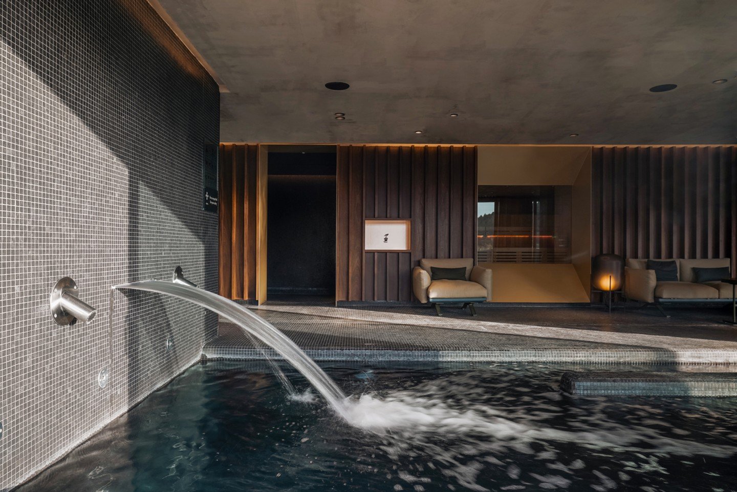 The indoor spa pool in stone and dark wood