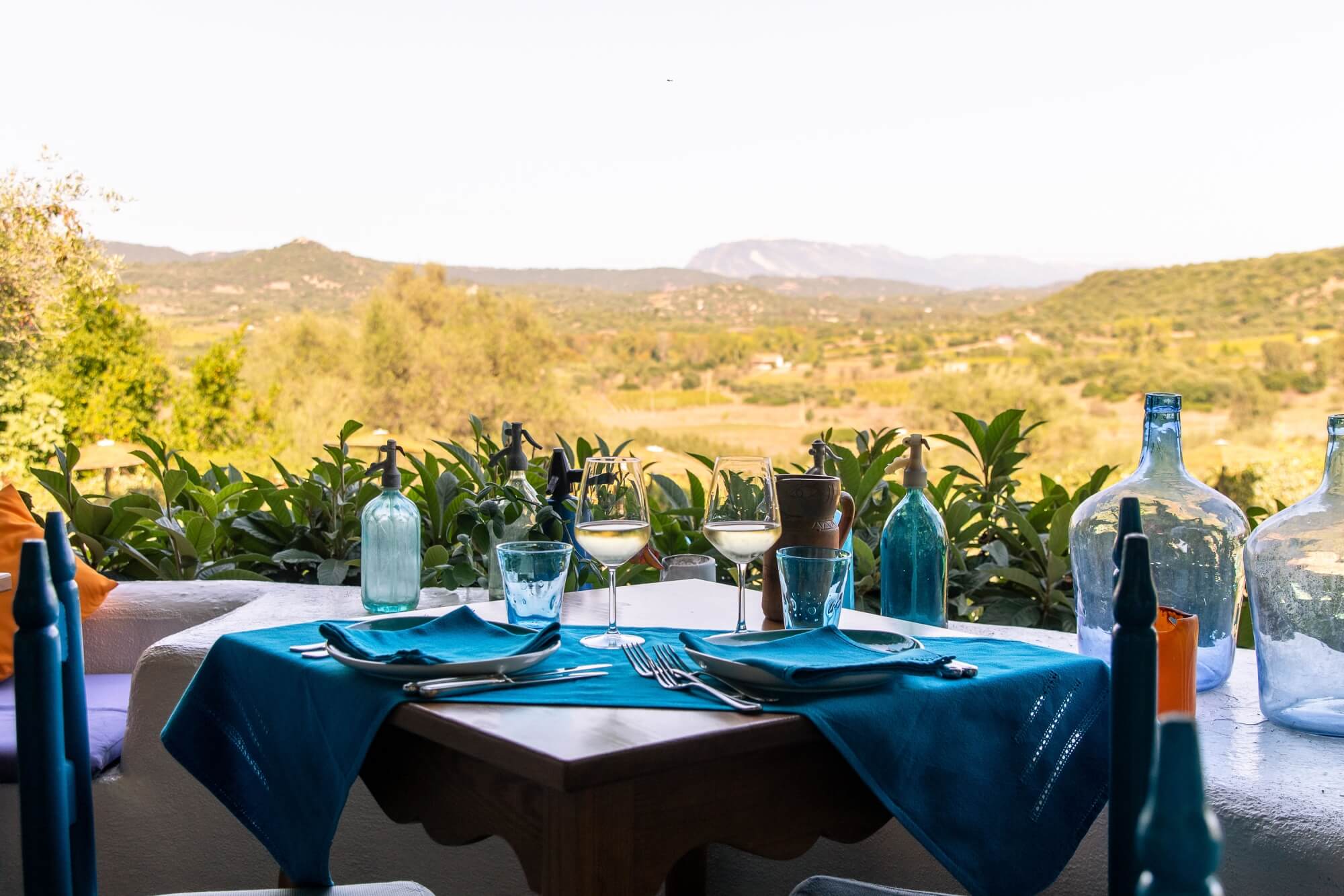 A table laid on a terrace above the vineyards and hills of Barbagia