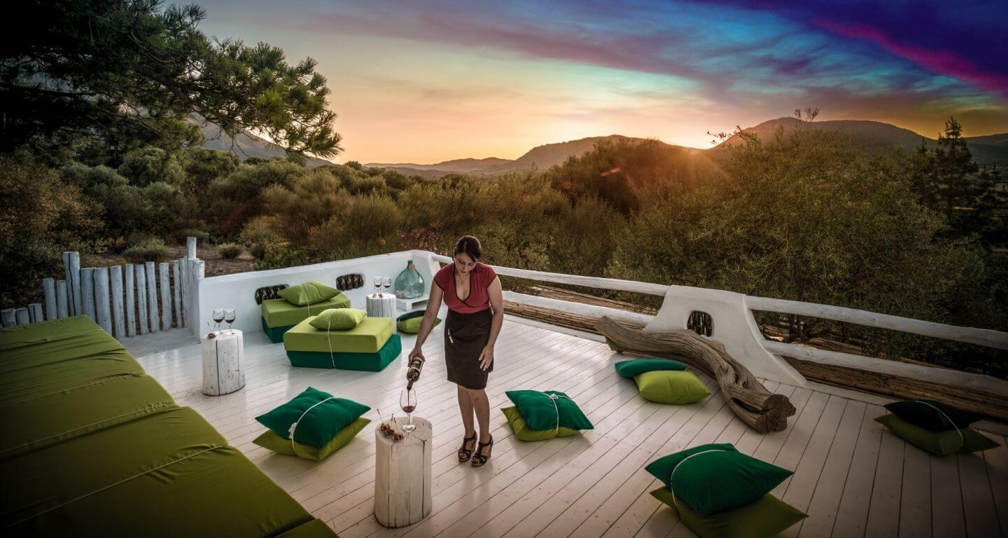 A whitewashed rooftop terrace at sunset, looking out to the hills of the interior