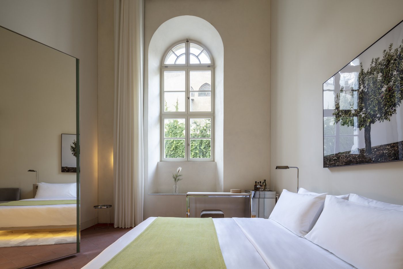 A room in the historic wing, with an arched window and a free-standing bath
