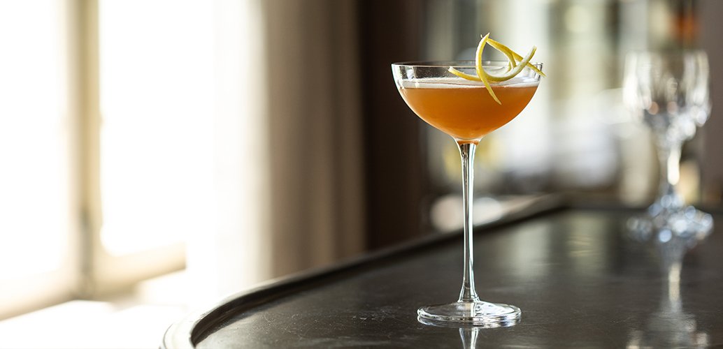 A cocktail on the dark counter of The Library Bar