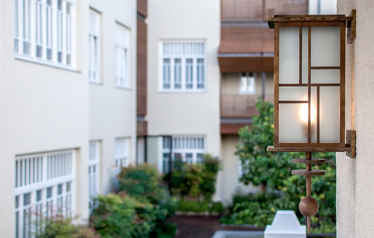 A brass lantern and planted courtyard between the two restored buildings