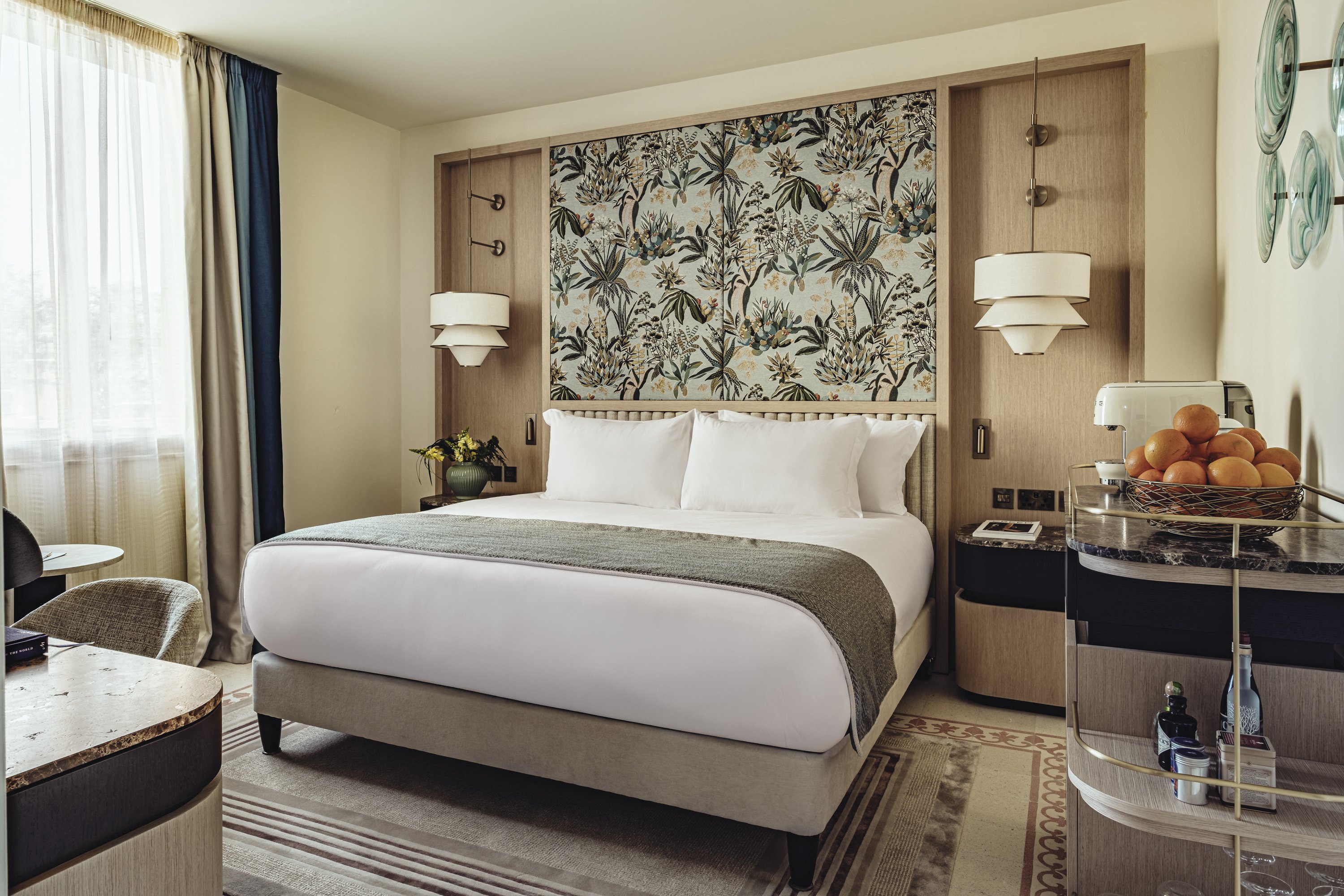A Signature Room with a botanical headboard and a bowl of oranges