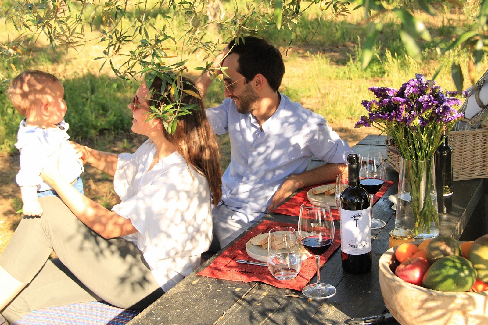 A table set outdoors with the estate's own wine and flowers