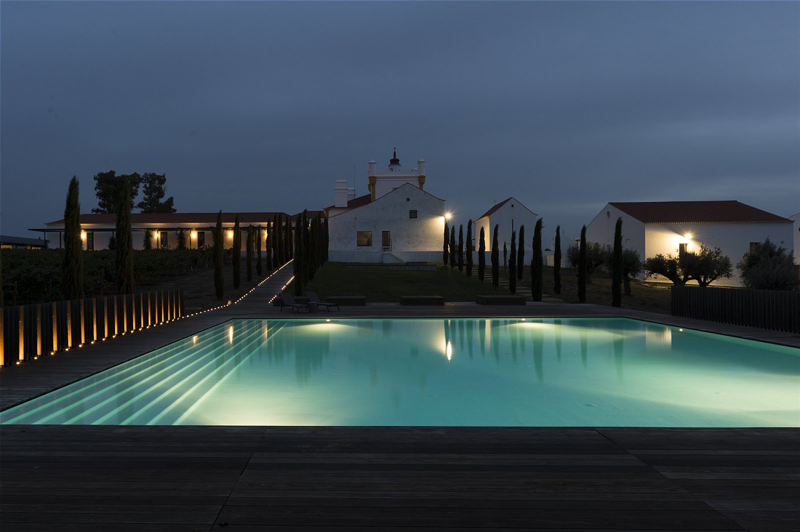 The outdoor pool at dusk mirroring the white chapel and buildings