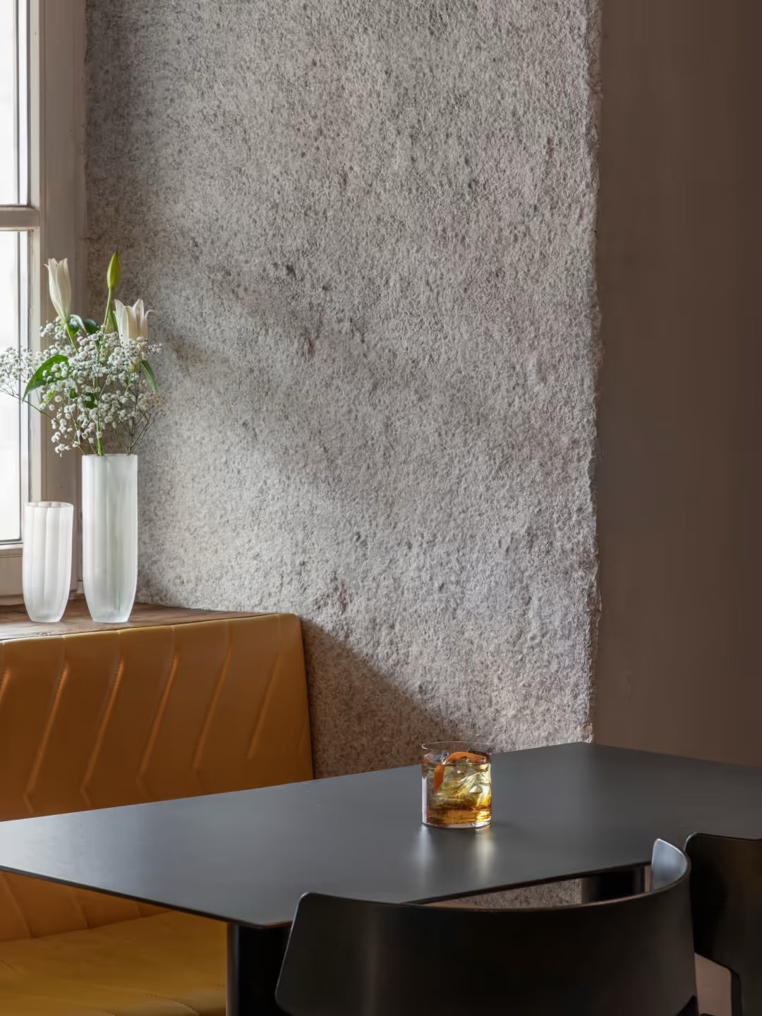 The ground-floor restaurant, a tan leather banquette against a rough plaster wall