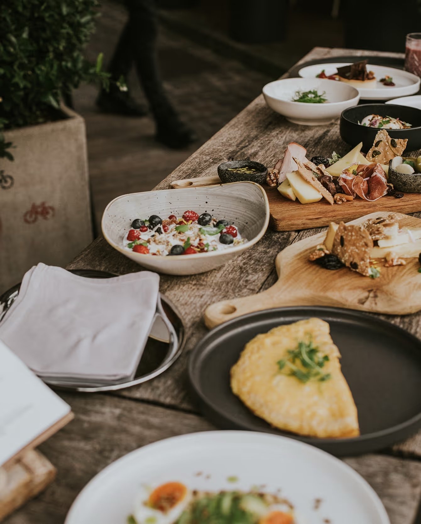 Breakfast laid out on a wooden table beside the Ljubljanica