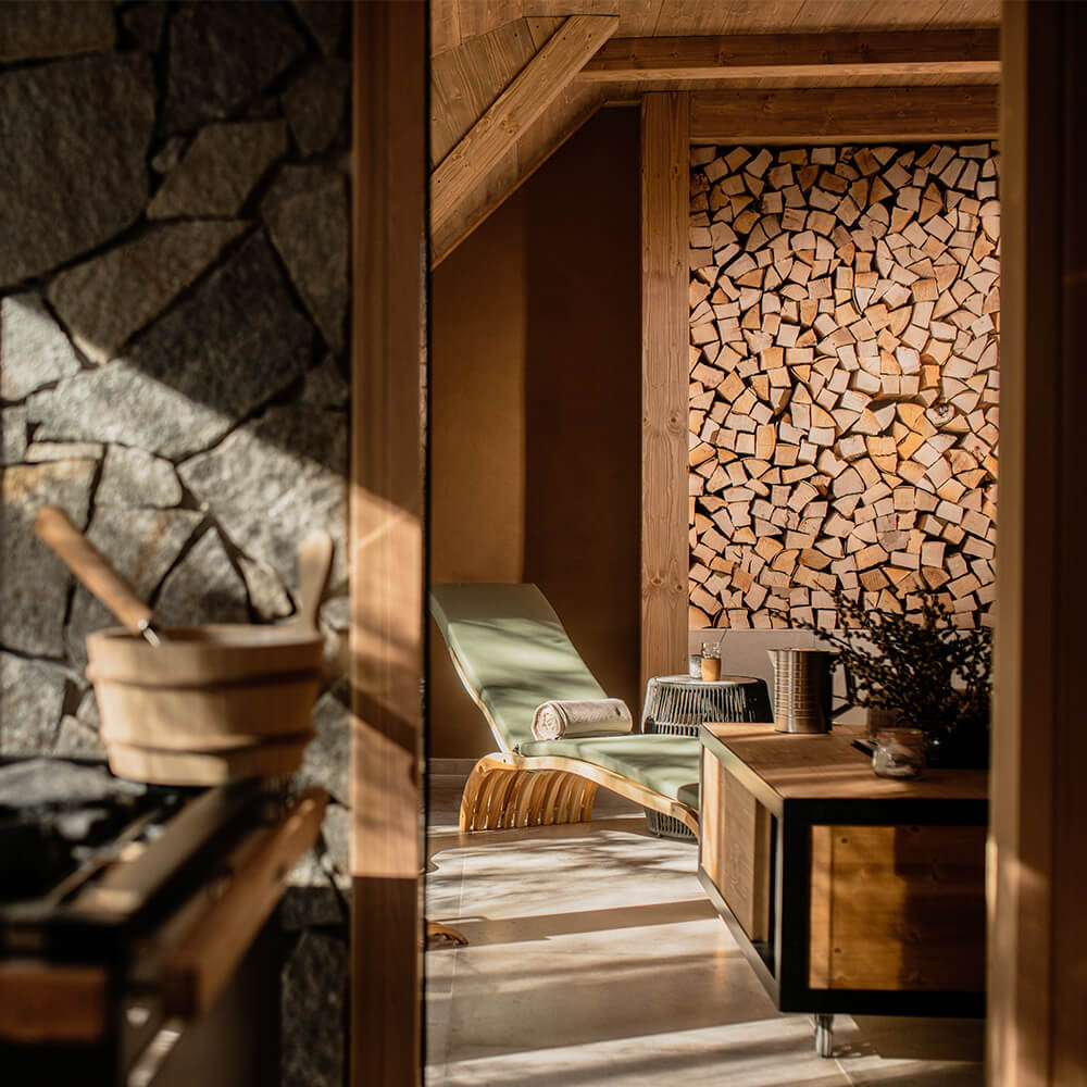 The spa relaxation room, a lounger beside a stacked-log wall