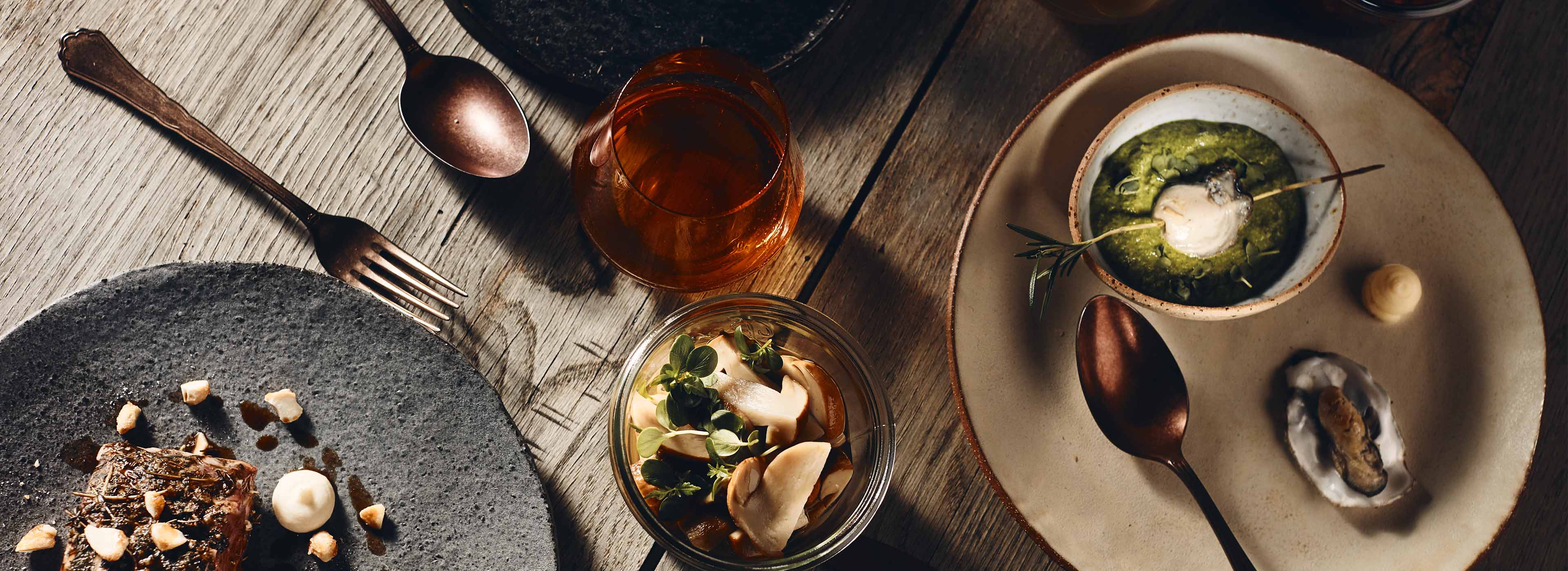Seasonal dishes plated on bare wood, seen from above