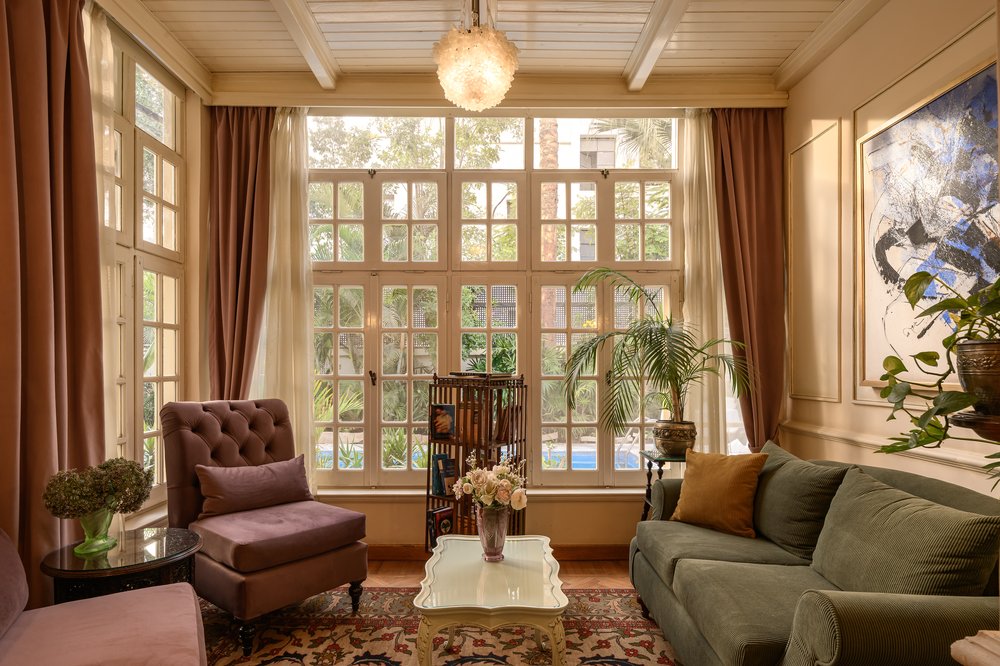 A period drawing room with tall lattice windows onto the garden