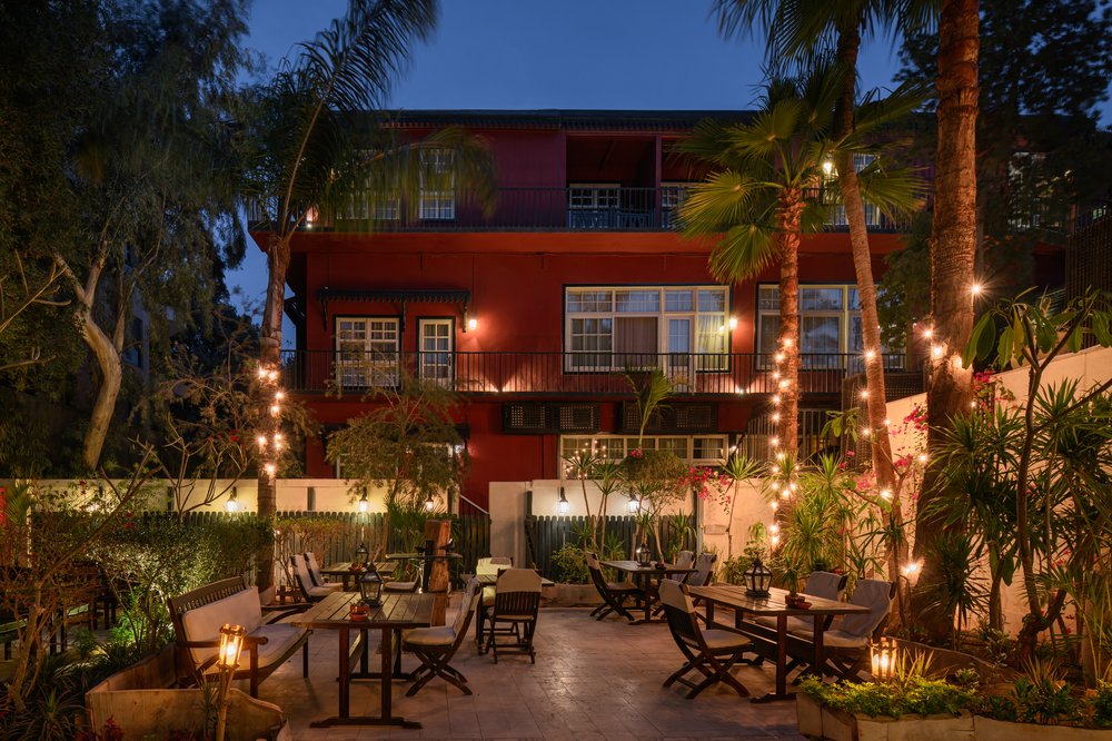 The ochre-red elevation and garden terrace lit at dusk