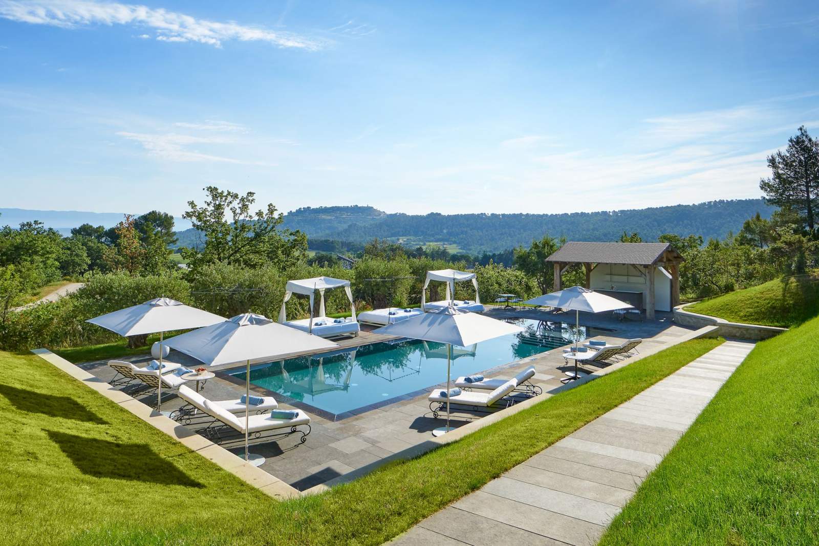 The outdoor pool above the vineyards and the hills of the Luberon