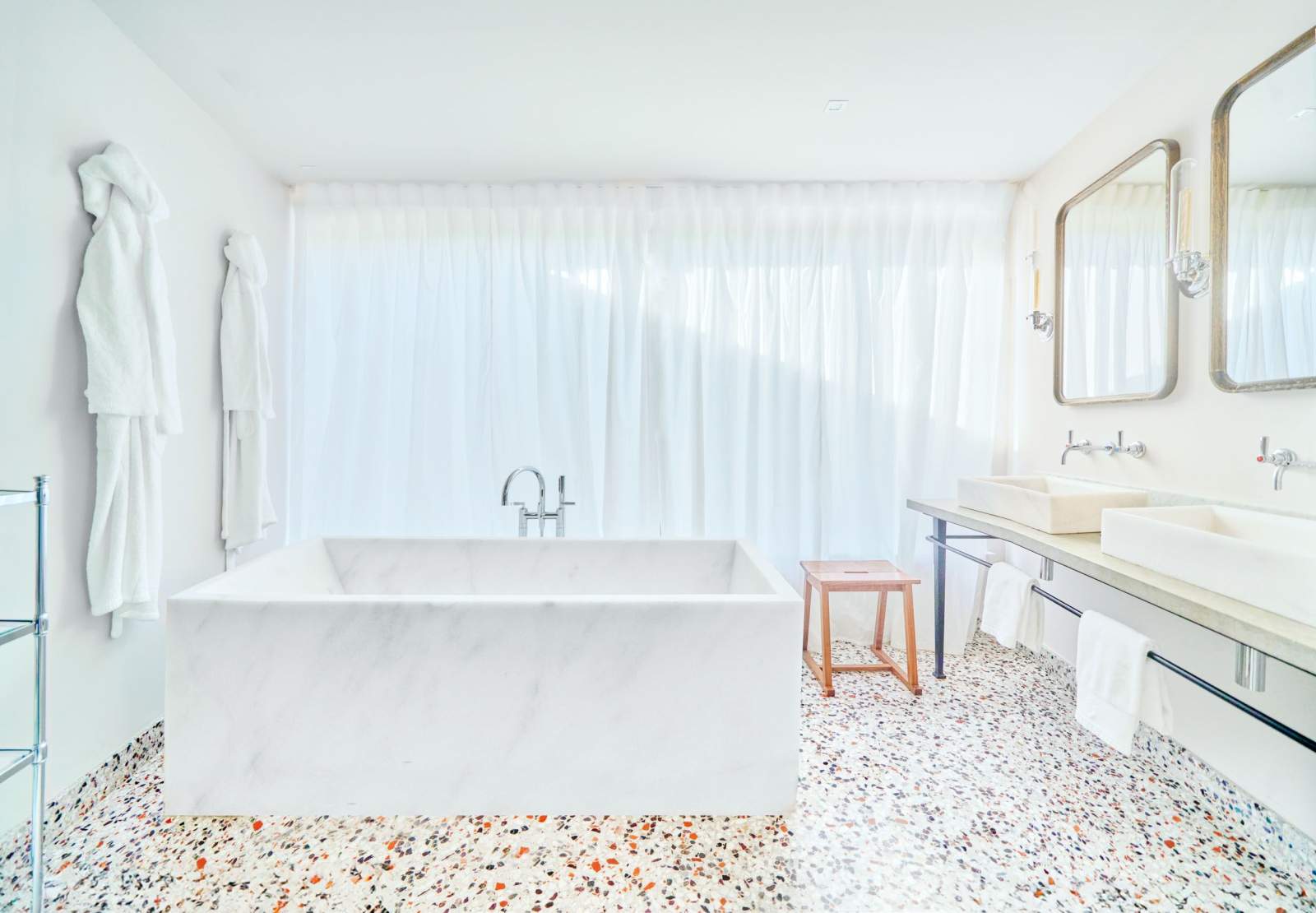 A suite bathroom in white marble with a terrazzo floor