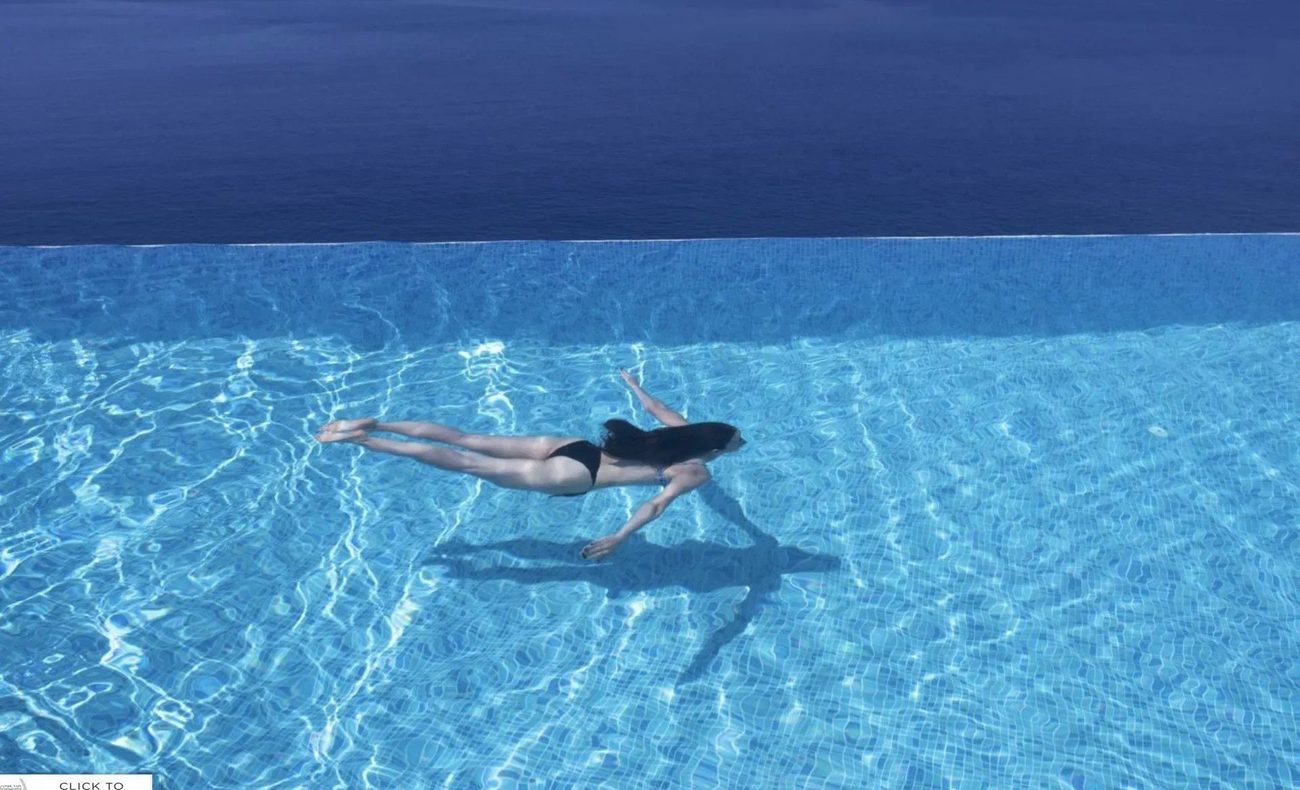 The infinity pool set above Kalkan Bay, loungers under a white parasol